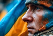 Український військовий крупним планом з бойовим розфарбуванням на обличчі, символ мужності та захисту України.
