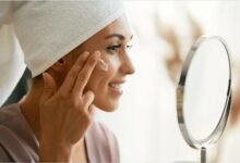 Женщина наносит крем в домашней ванной