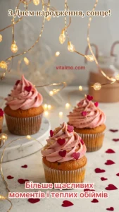 Капкейки з рожевим кремом і сердечками стоять на святковому столі в оточенні теплих гірлянд.