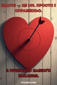 Романтичне привітання до річниці кохання з червоним серцем-мішенню та стрілою посередині на дерев’яному фоні.