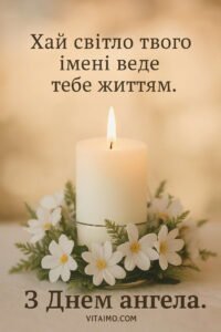 Біла запалена свічка у вінку з білих квітів і зелені на м’якому теплому тлі для привітання з Днем ангела.