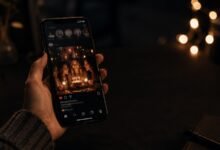 Smartphone showing a birthday post for friends in a dark cozy setting