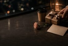 Small birthday gesture with gift, coffee, flower, and card in a dark cozy setting